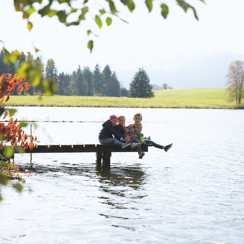 Steg am Huttler Weiher bei Roßhaupten Kinder sitzen auf dem Steg am Huttler Weiher bei Roßhaupten im Ostallgäu.