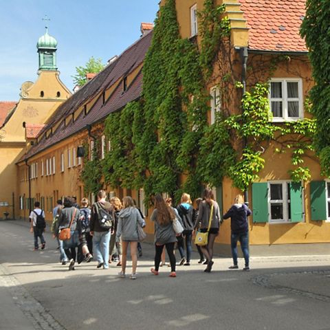 Führung durch die Fuggerei Augsburg Besuchergruppe macht Führung durch die Fuggerei in Augsburg
