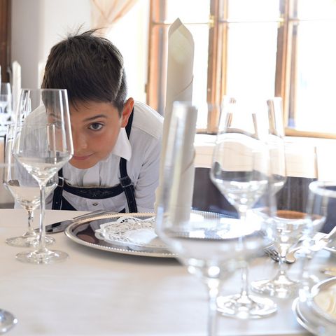 Eingedeckter Tisch im Schlosshotel zu Hopferau Junge betrachtet einen eingedeckten Tisch im Schlosshotel zu Hopferau im Ostallgäu.