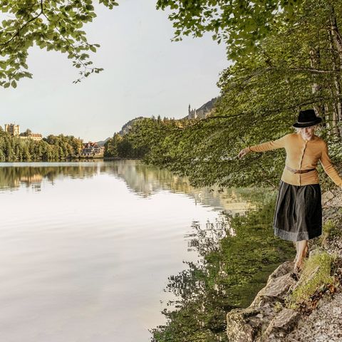 Spaziergang am Alpsee bei Hohenschwangau Spaziergängerin am Alpsee bei Hohenschwangau im Ostallgäu.