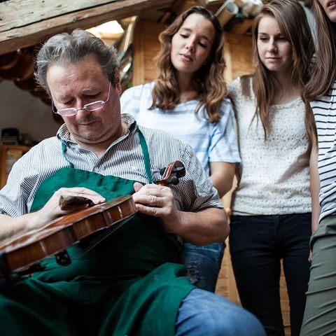 Besuch in der Geigenbauer-Werkstatt Besucher schauen dem Geigenbauer über die Schulter in Füssen im Ostallgäu.