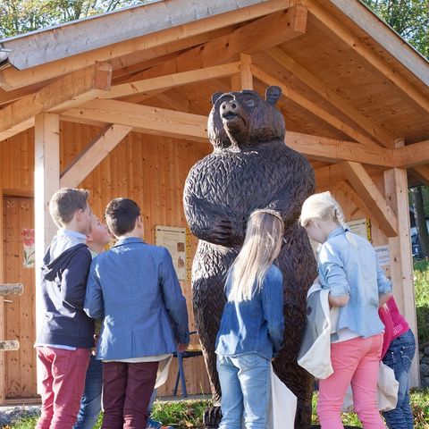 Station auf dem Honigerlebnispfad in Seeg Kinder mit einer Bär Statue auf dem Honigerlebnispfad in Seeg