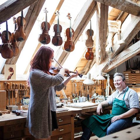 Geigenspielerin in der Werkstatt Geigenspielerin in der Geigenbauer-Werkstatt in Füssen im Ostallgäu.