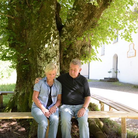 Ruhebank an der Kirche Maria Rain Älteres Pärchen genießt eine Pause auf der Ruhebank an der Kirche Maria Trost bei Nesselwang im Ostallgäu.