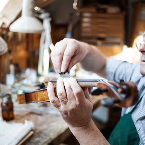 Geigenbauer bei der Feinarbeit Geigenbauer bei der Feinarbeit in Füssen im Ostallgäu.
