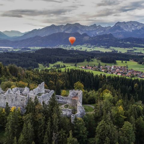 Burgruinen Hohenfreyberg und Eisenberg bei Eisenberg Burgruinen Hohenfreyberg und Eisenberg bei Eisenberg im Ostallgäu mit Heißluftballon und Bergen im Hintergrund.
